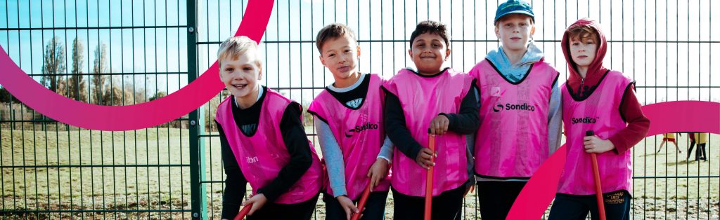 Happy children playing hockey at a Premier Education Holiday Camp