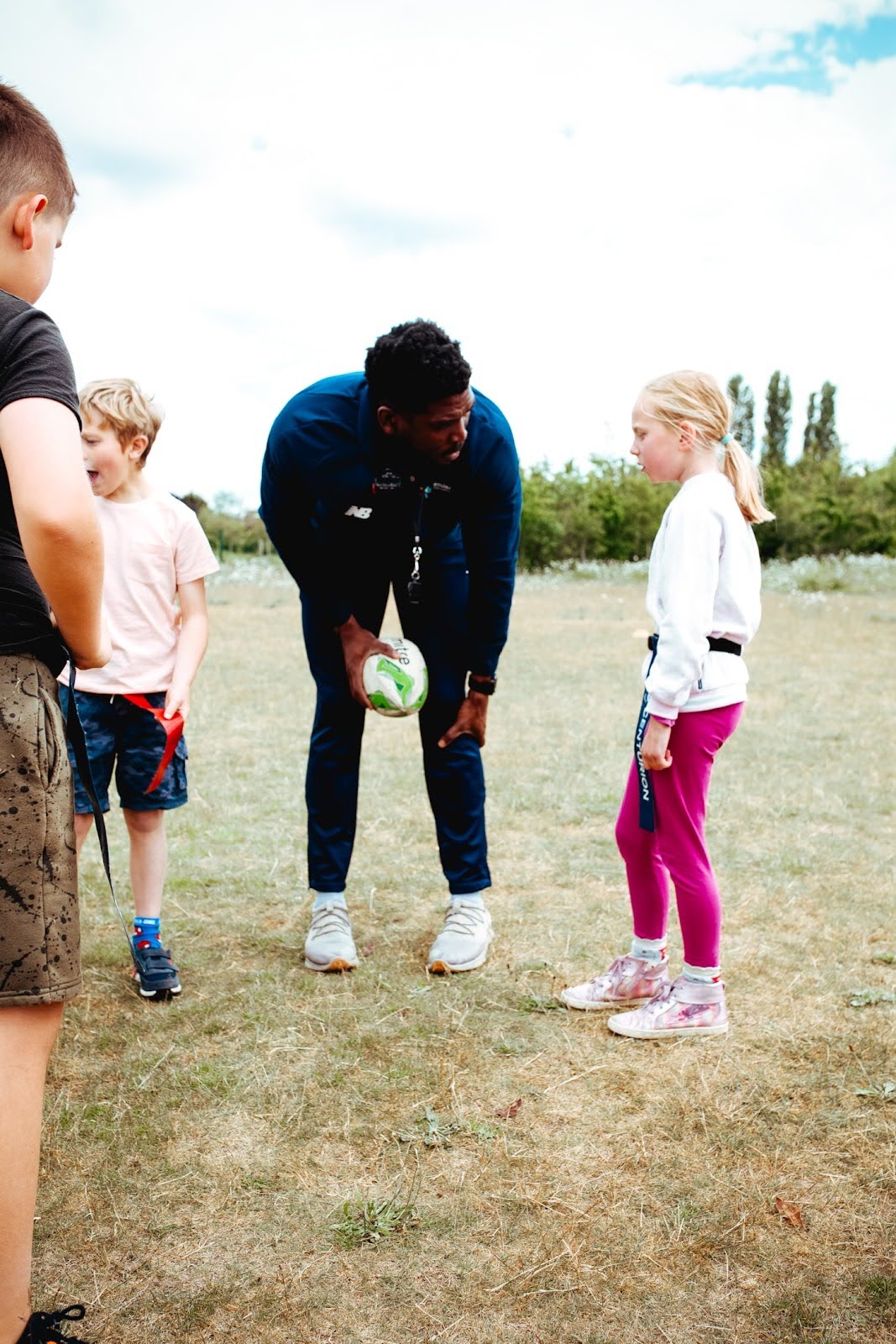 A Premier Education coach talking to a young girl