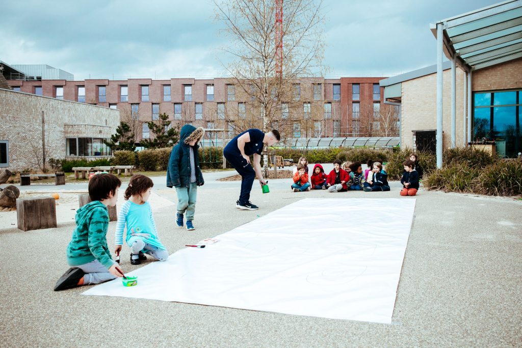 Premier education coach teaching children how to paint