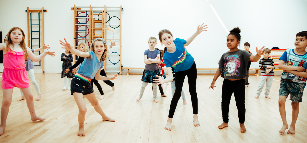 Pupils doing jazz hands during a dance class