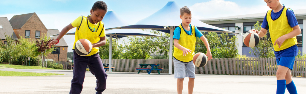 Children playing basketball at a Summer Holiday Camp