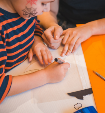 Child creating mummies bunting in autumn