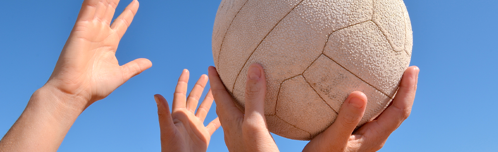 Netball closeup hands ball 1024x314 1