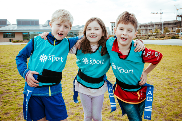 3 children playing tag rugby.