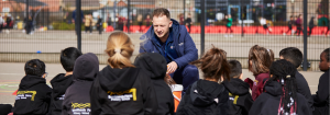 Premier Education Coach with a group of primary school children